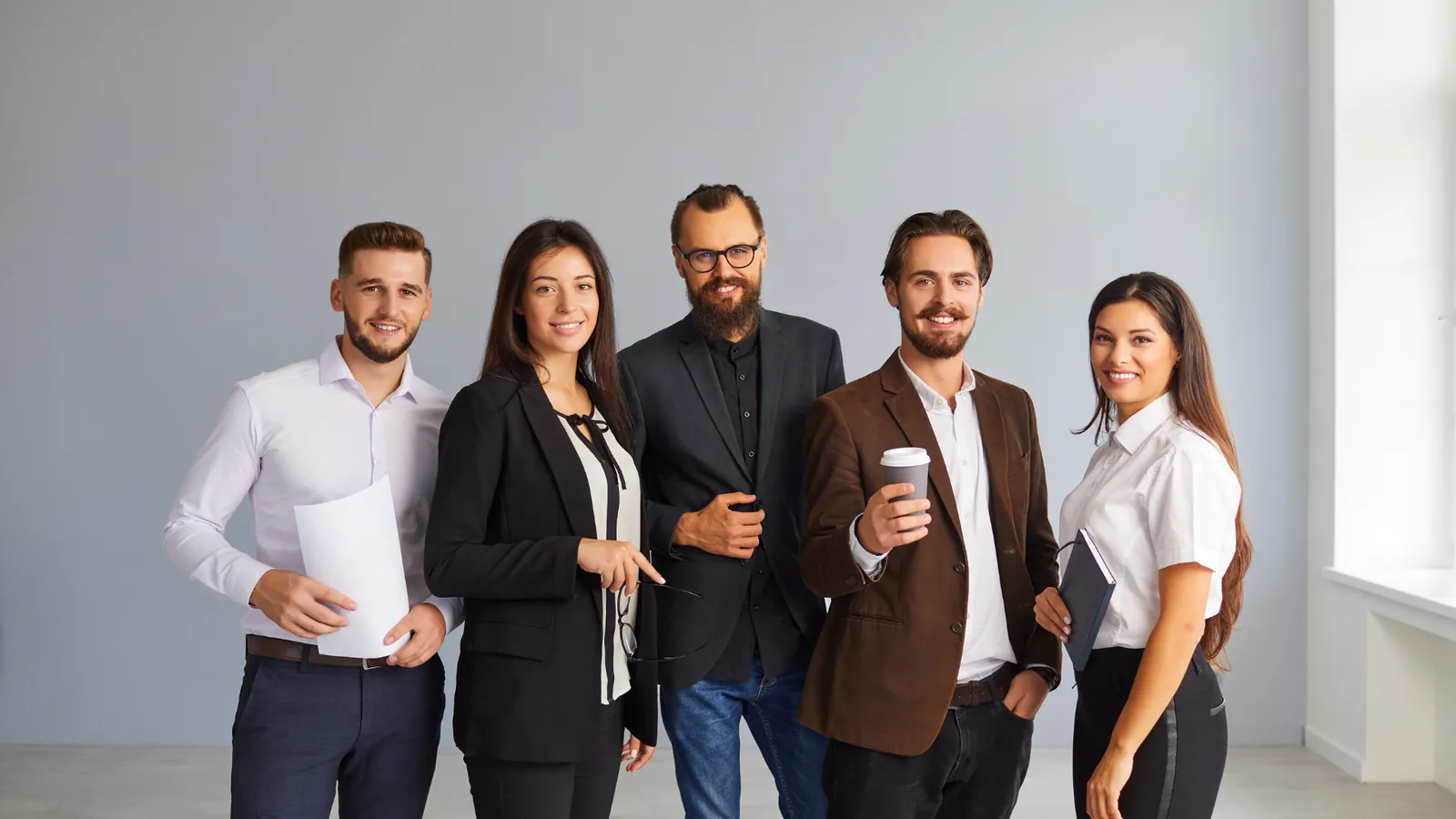 Five colleagues from a small business team standing together.